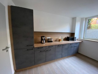 Foto: Gästezimmer im Seniorenheim Jößnitz - unsere moderne Küche mit einem großen Kühlschrenk, Geschirrspüler und zahlreichen Regalen